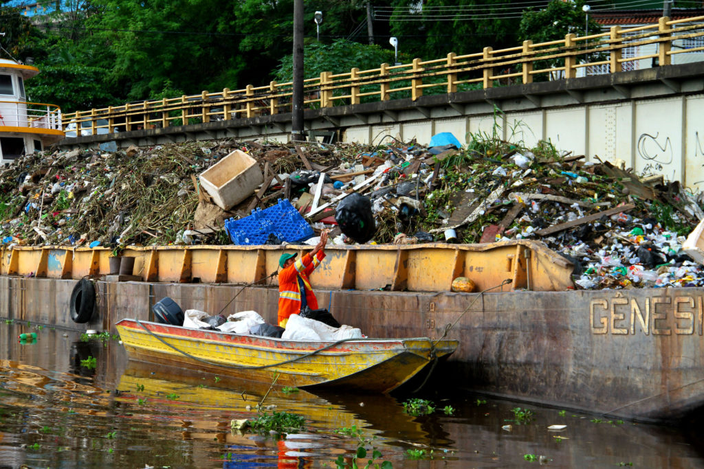 Balsa recolhe lixo de igarapé em Manaus.