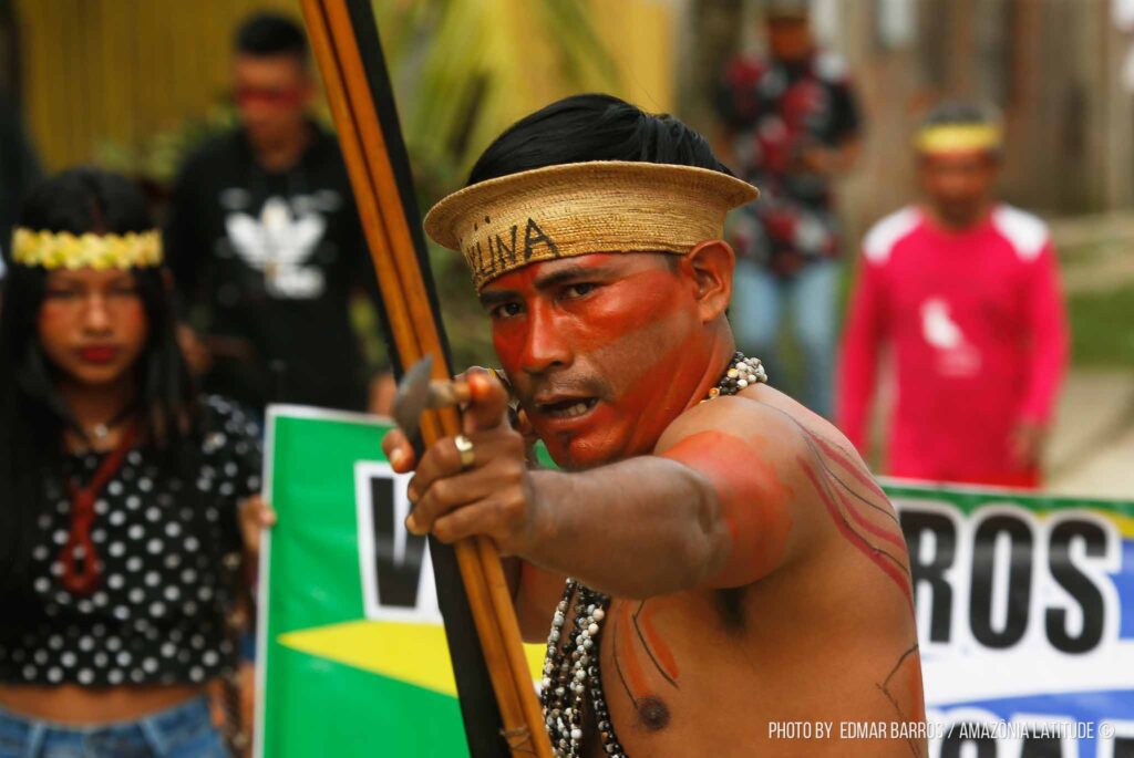 Um indígena estica um arco e flecha durante o protesto